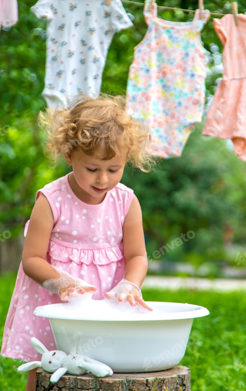 Preview: The child washes clothes and toys. Selective focus.