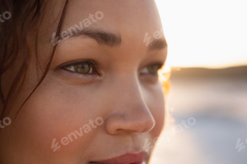 Preview: Close-up of beautiful mixed race woman looking away on the beach