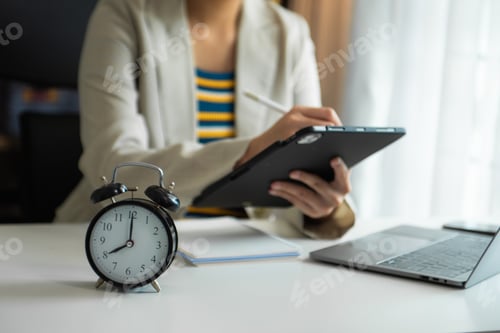 Preview: Alarm clock on the desk. Business hand using smartphone, laptop and tablet working in modern