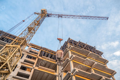 Preview: Low angle shot of a crane with equipment on a construction site with a new building infrastructure