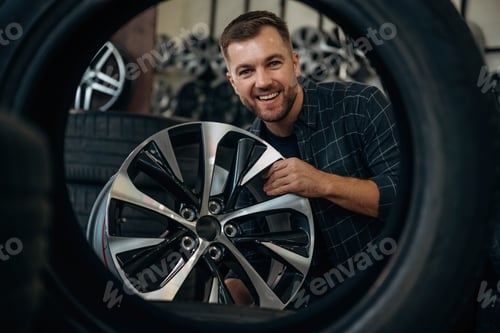 Preview: Brand new disk. Man worker is maintenance station with tires, wheels