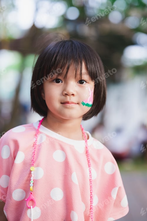 Preview: Cute Asian girl with sweet smile looking at camera. Child wear pink shirt.