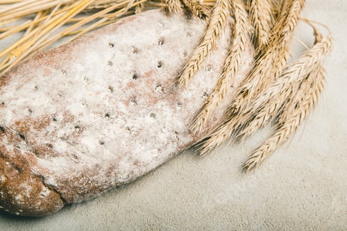 Preview: Ripe wheat with bread on grey rustic background