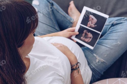 Preview: Pregnant woman holds ultrasound photo on