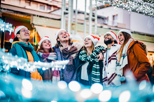 Preview: Happy friends group walking at european city on winter day wearing santa claus hat