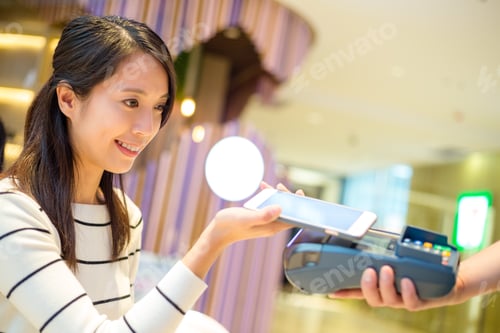 Preview: Woman pay with mobile phone by NFC technology