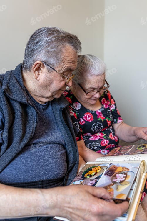 Preview: An elderly man and woman are looking at family photo albums.