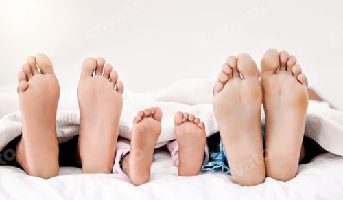 Preview: Earth descending, heaving ascending. Shot of a familys bare feet while sleeping in bed together.