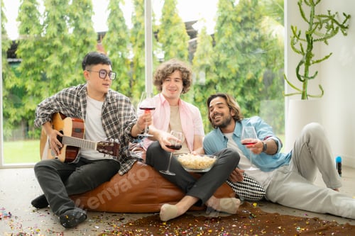Preview: Multiethnic group of friends having fun playing guitar and singing together at home