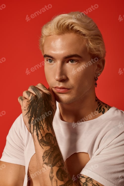 Preview: Stylish young man shows confidence and modern style against vibrant backdrop