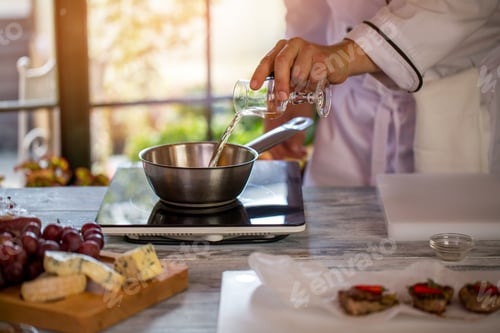Preview: Glass pouring liquid on saucepan