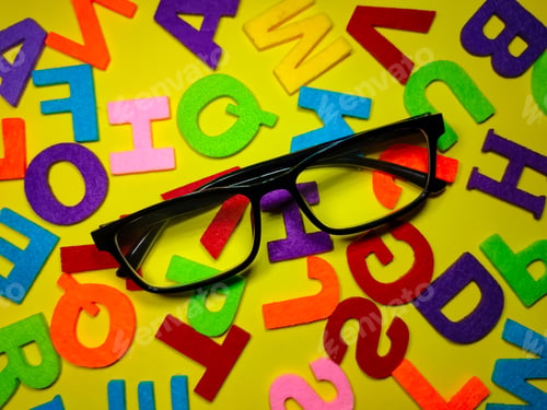 Preview: Selective focus.Eye glasses and colorful word on yellow background