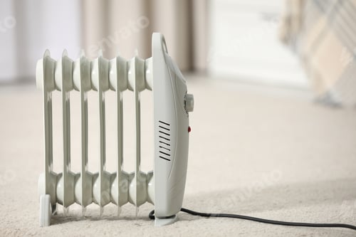 Preview: Modern electric heater on floor at home. Space for text