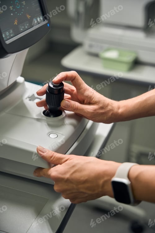 Preview: Optometrist adjusting eye examination equipment controls