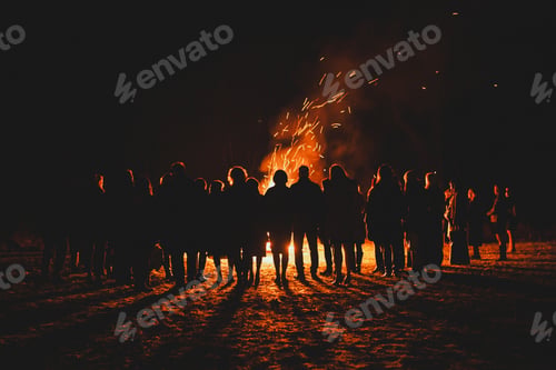 Preview: silhouettes of people standing around large bonfire with sparks flying around