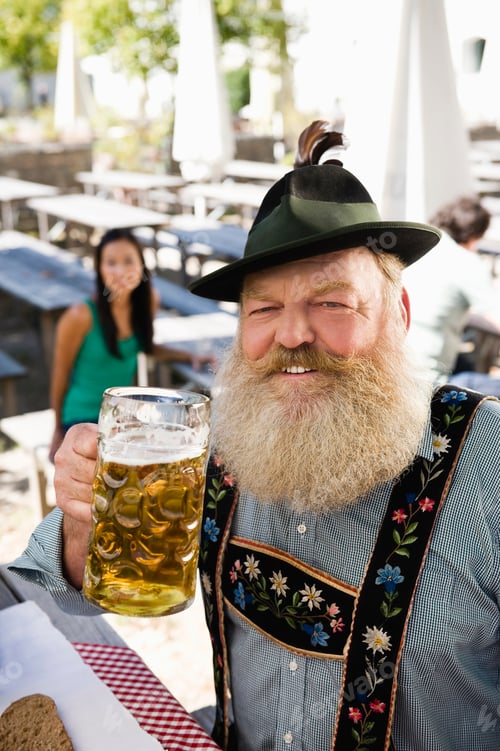 Preview: Germany, Bavaria, Upper Bavaria, Senior man in beer garden holding beer stein, portrait