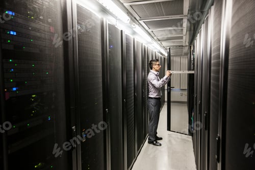 Preview: Hispanic man technician doing diagnostic tests on computer servers in a large server farm.
