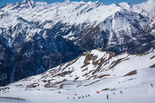 Preview: Many skiers ride in Alps at sunny winter day. Winter landscape - Panorama of the ski resort with ski