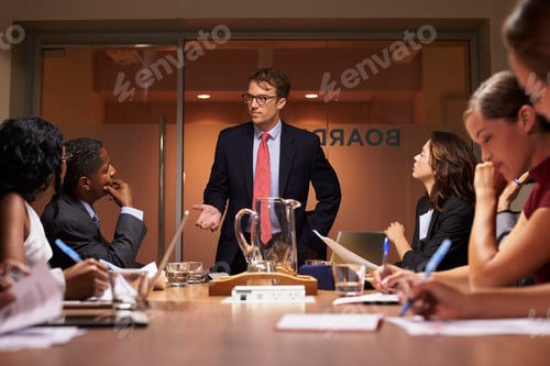 Preview: Businessman stands addressing team at meeting, low angle