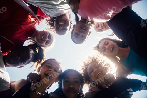 Preview: Low angle view of schoolgirl soccer team huddled in circle