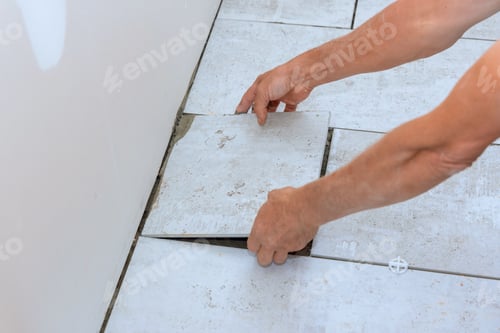 Preview: Ceramic floor tiles are being placed over adhesive in a bathroom by tiler