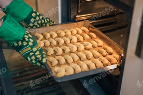 Preview: Unrecognizable person takes a tray of Christmas cookies to the oven