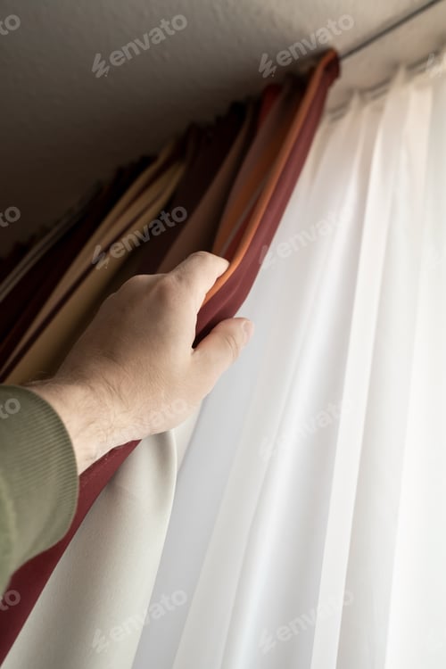 Preview: Male hand closes the blackout curtains on the window. Bottom view.