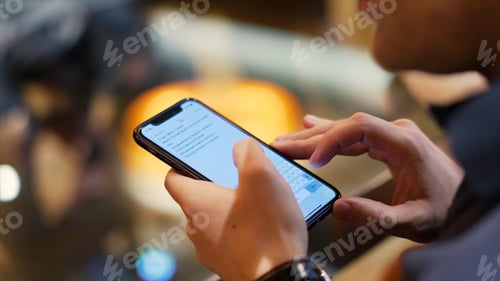 Preview: Young hipster guy texting with his mobile phone at the bar. Stock. A young man with a phone in his