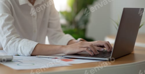 Preview: Close up of student girl hands comparing notes on laptop computer sitting on a desk. female using