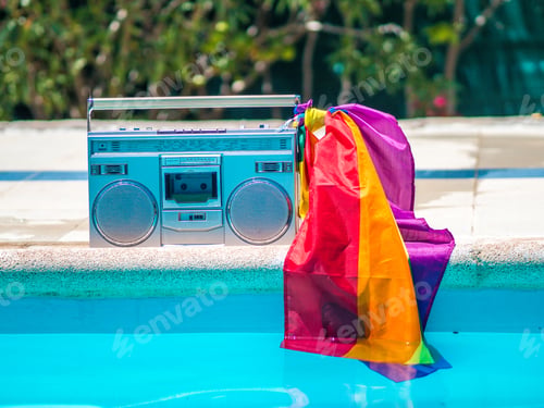 Preview: Boombox with colorful LGBT flag at poolside in sunlight