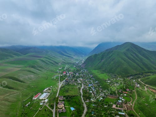 Preview: Village Along River in Green Valley Cloudy Day