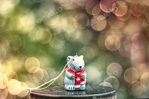 Preview: Celebratory ceramic figurine of a rat on a blurred background with a bokeh. New Year symbol.