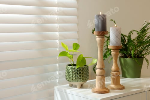 Preview: Pair of beautiful wooden candlesticks and houseplants on white table in room, space for text