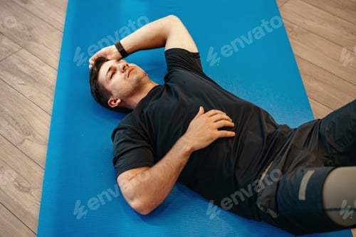 Preview: Young muscular caucasian handsome man doing abs exercises on mat