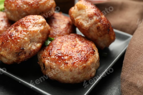 Preview: Delicious roasted patties on black table, closeup