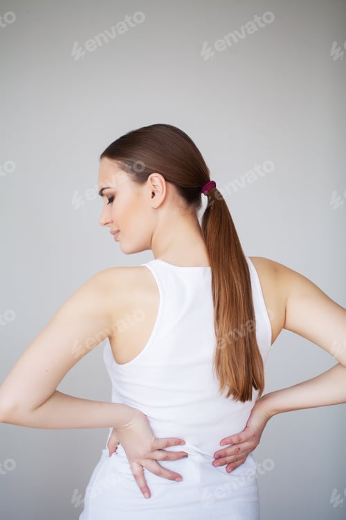 Preview: Woman Experiencing Back Pain in Front of Wall
