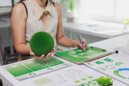 Preview: Person doing esg reporting holding green moss sphere