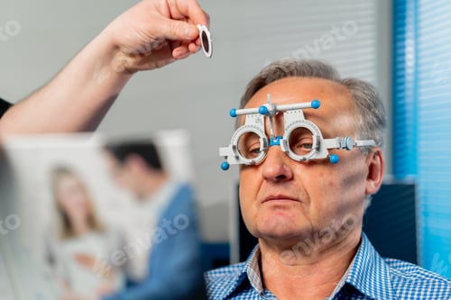 Preview: close up In an ophthalmology clinic an obese doctor selects suitable lenses for a patient
