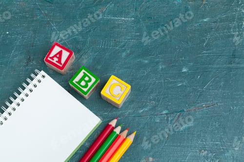 Preview: Notepad on wooden table and wood alphabet blocks. creative photo