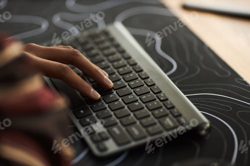 Preview: Young Adult Black Woman Typing on Wireless Keyboard in Modern Workspace