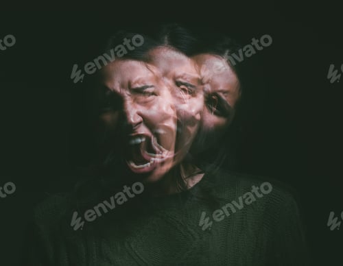 Preview: Studio shot of a young woman experiencing mental anguish and screaming against a black background