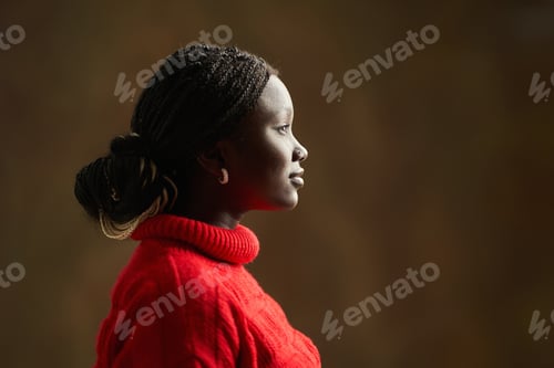 Preview: Young black woman wearing red sweater and looking right side