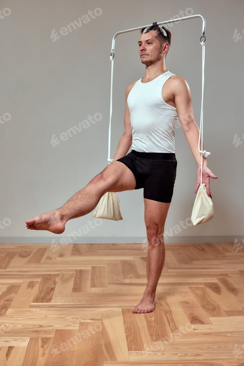 Preview: A man does exercises on a Pilates reformer, reformers for Pilates gymnastics.