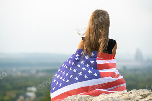 Preview: Blonde Woman Wrapped in American Flag Looking Away