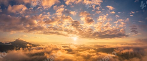 Preview: Mountains in low clouds at sunrise in summer. Aerial view