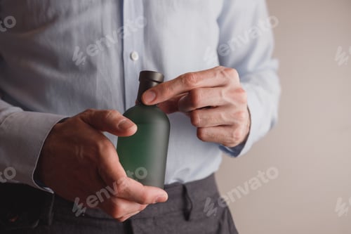 Preview: Man in formal wear holding perfume bottle, closeup. Space for text.