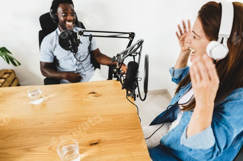Preview: Multiracial hosts streaming podcast together at record studio - Focus on woman microphone