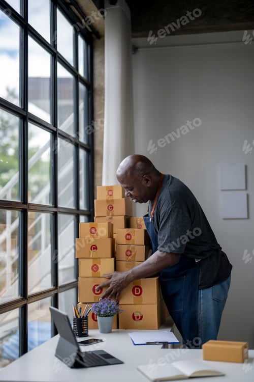 Preview: A man is sorting through a stack of boxes in a room