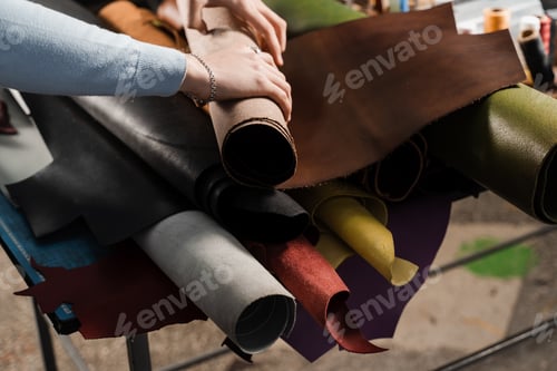 Preview: Craftsman selecting genuine leather rolls in leather goods workshop