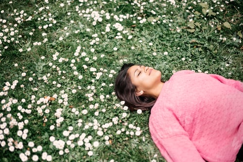 Preview: Woman relaxing in a field of flowers